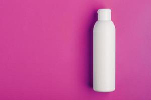 White bottle on pink background. Free space for text. photo