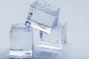 hielo con gotas de agua de deshielo de cerca sobre un fondo blanco. foto