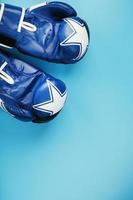 A pair of leather Boxing gloves on a blue background, free space. photo