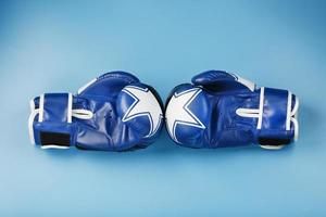 A pair of leather Boxing gloves on a blue background, free space. photo