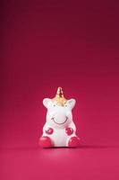 Unicorn figurine on a pink background. Free space. photo