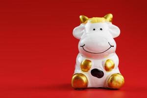 Figurine of a cow from on a red background, free space for text. photo