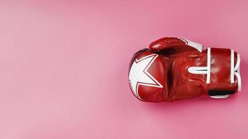 Red Boxing glove on a pink background, free space. The concept of overcoming difficulties. photo