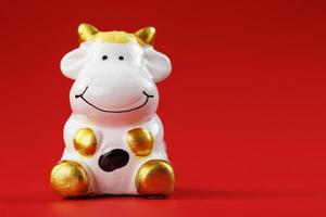 Cow figurine on a red background, new year's concept. Free space. photo