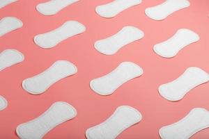 Sanitary pad on a pink background in the form of a diagonal pattern. Textured background over the entire screen. photo
