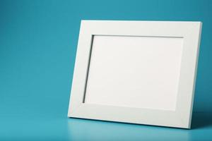 White and black photo frame with empty space on a blue background.