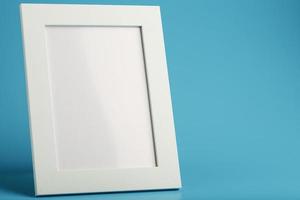 White and black photo frame with empty space on a blue background.