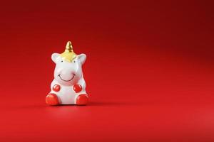 Unicorn figurine on a red background with free space. photo