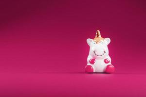 Unicorn figurine on a pink background. Free space. photo