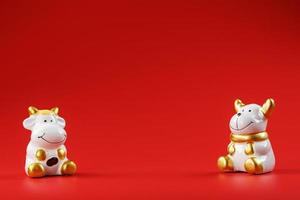 A pair of cow and bull Figures on a red background, with free space. photo