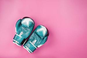 Blue Boxing gloves on a pink background, free space. photo