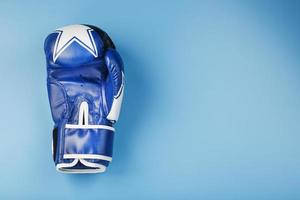 Blue Boxing glove on a blue background, free space. photo