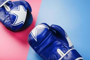 Boxing blue gloves on a pink and blue background diagonally. photo