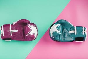 A pair of blue and pink boxing gloves on a blue and pink background. photo