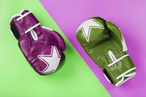 A pair of green and pink boxing gloves on a light green and pink background. photo
