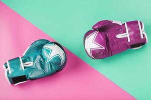 A pair of blue and pink boxing gloves on a blue and pink background. photo