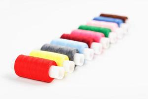 Sewing threads of different colors on reels on a white background. Free space, close-up. Isolate photo