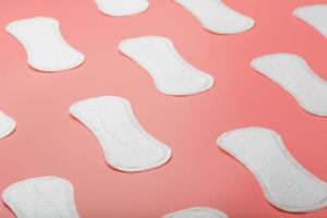 Sanitary pad on a pink background in the form of a diagonal pattern. Textured background over the entire screen. photo