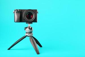 Professional camera on a tripod, on a blue background. Record videos and photos for your blog or report.