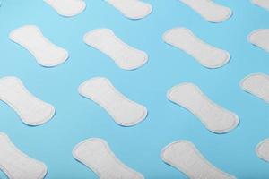 Many Sanitary pads on a blue background in the form of a diagonal pattern. Textured background all over the screen. photo