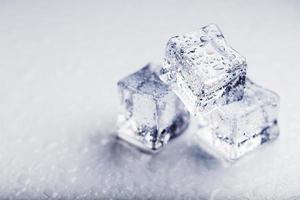 Ice with meltwater drops close-up on a white background. photo