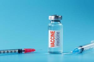 Medicines with syringe Vaccine ampoule on a blue background. photo