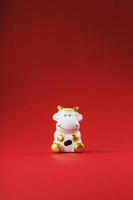 Cow figurine on a red background, new year's concept. Free space. photo