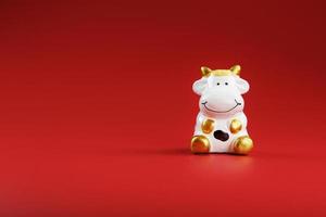 Cow figurine on a red background, new year's concept. Free space. photo