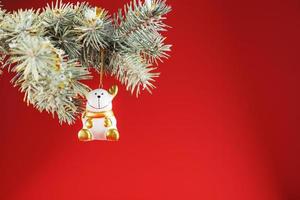 Bull figure on a Christmas tree on a red background, free space for text. photo