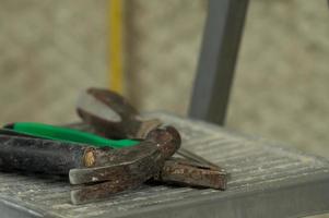 Set of three construction tools on a ladder hammer, pliers and screwdriver. photo