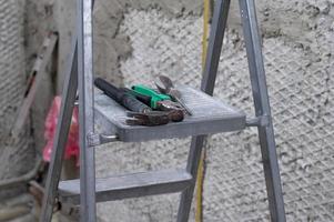 conjunto de tres herramientas de construcción en un martillo de escalera, alicates y destornillador. foto