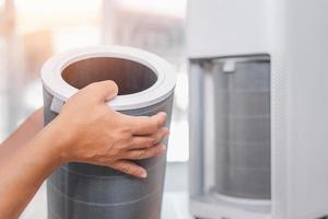 Close up hand a man hold old dust filter of Air purifier check and change when the filter is expired photo