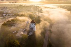 earlier foggy morning and aerial panoramic view on medieval castle and promenade overlooking the old city and historic buildings near wide river photo