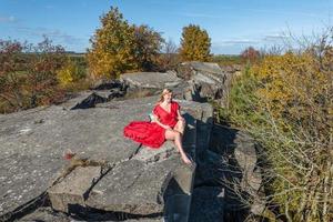 aerial view on girl in red dress lying on rock or concrete ruined structure photo