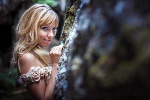 beautiful blonde girl in a white dress with a corset in a deep dark cave photo