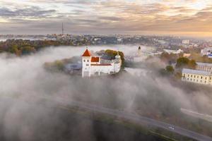 earlier foggy morning and aerial panoramic view on medieval castle and promenade overlooking the old city and historic buildings near wide river photo