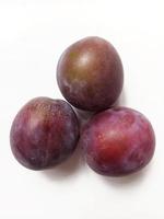 ripe juicy plums on white background photo