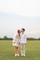 Happy young Asian couple in bride and groom clothing photo