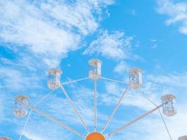 Old styled Ferris wheel against a blue sky with light clouds photo