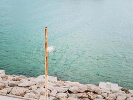 Lonley rusty lantern on a rocky shore of the sea photo