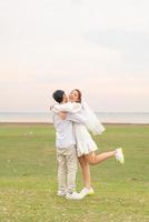 Happy young Asian couple in bride and groom clothing photo