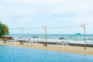 dinning table and chair on beach with sea background photo