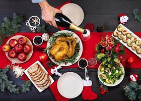 Baked turkey. Christmas dinner. The Christmas table is served with a turkey, decorated with bright tinsel and candles. Fried chicken, table.  Family dinner. Top view photo