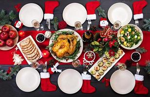 Baked turkey. Christmas dinner. The Christmas table is served with a turkey, decorated with bright tinsel and candles. Fried chicken, table.  Family dinner. Top view photo