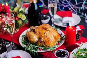 Baked turkey. Christmas dinner. The Christmas table is served with a turkey, decorated with bright tinsel and candles. Fried chicken, table.  Family dinner. photo