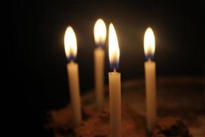 candles burning brightly on black background photo