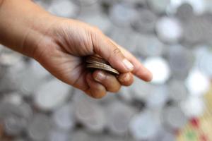 kid hand holding many Thai coins baht photo