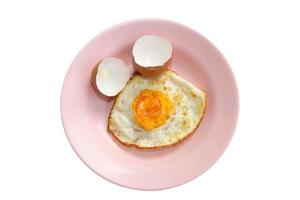 Fried egg in pink dish isolate on white background.