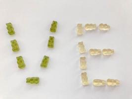 creative edible letter V and E made from gummy bears. Letter made from red, gelatinous and tasty candies. creative image of words. delicious high-calorie letter photo