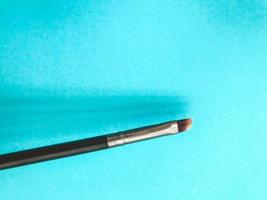 thin makeup brush. makeup brush with natural brown bristles. eye paint, eyebrow shaping. creating a new image. makeup artist tool. beautiful eyes and lips. makeup lines photo